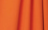 Tangerine-colored wrinkle-resistant fabric with smooth, seamless texture as a tangerine wrinkle-resistant background.